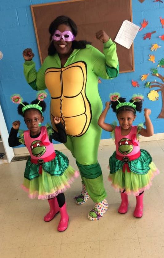 Person in turtle costume with two children in turtle dresses