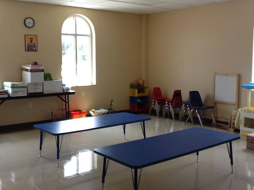 Empty classroom with two blue tables and small chairs