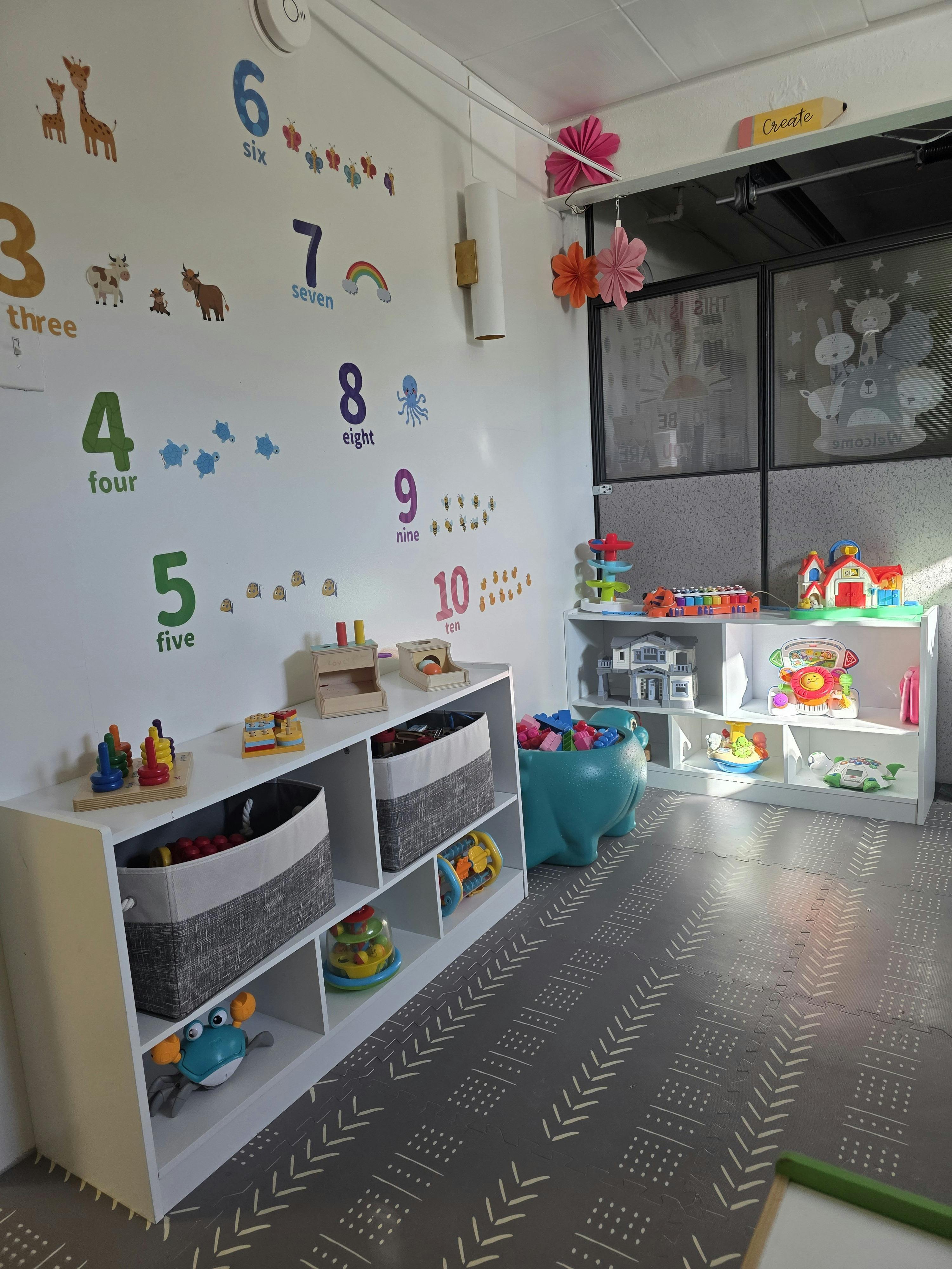 Playroom with educational number wall decals and shelves organized with toys