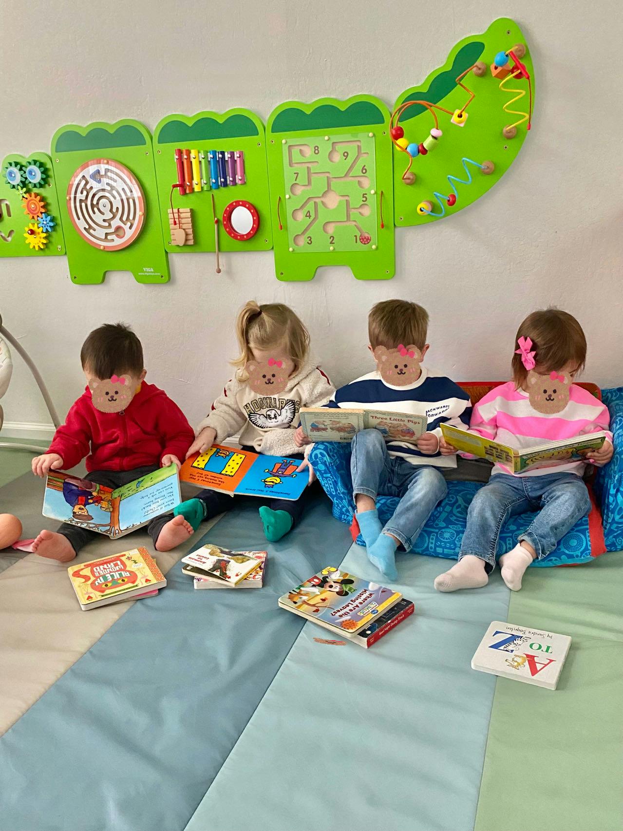 Four children sitting on the floor and reading books
