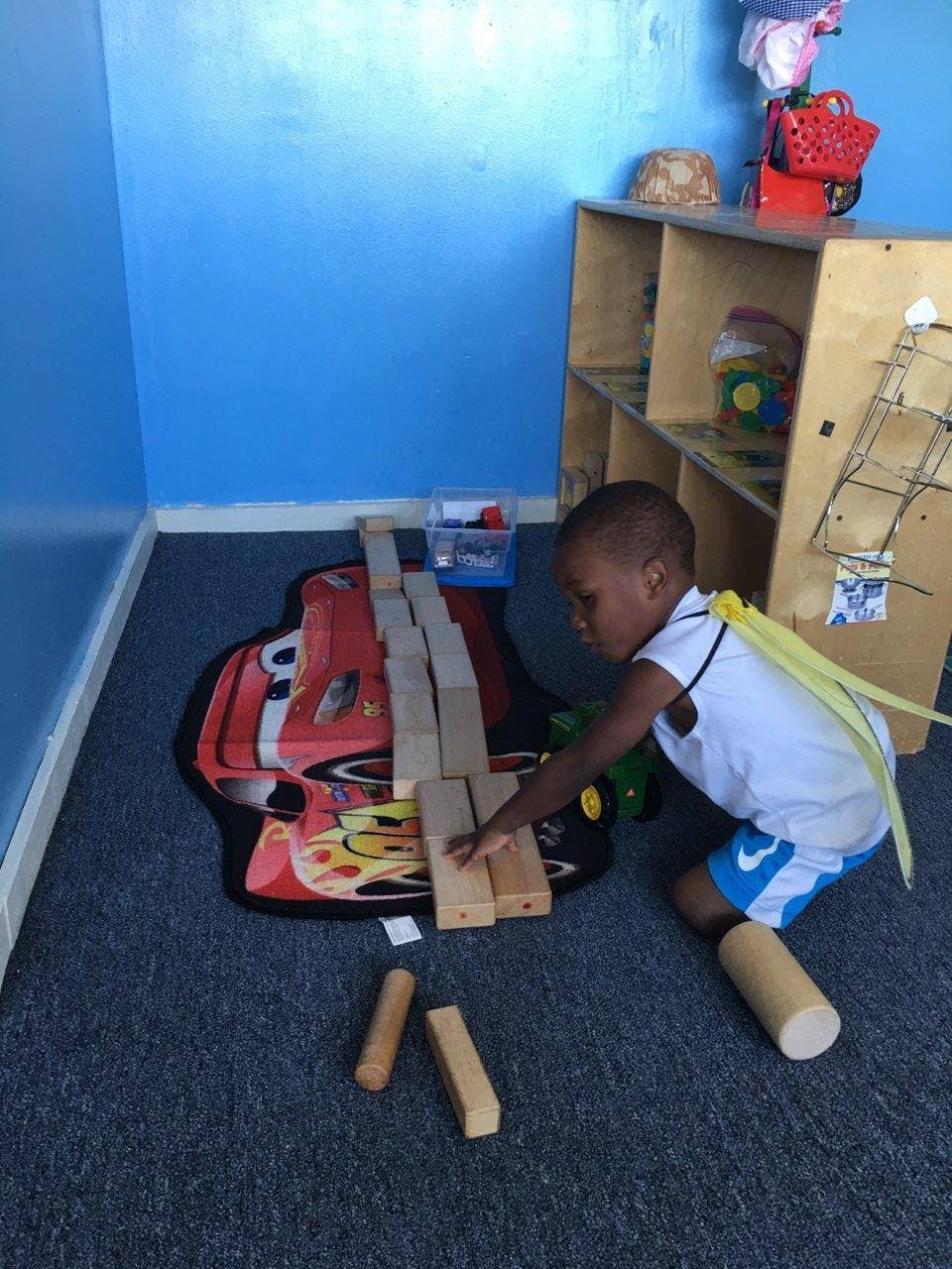Child playing with wooden blocks on a rug
