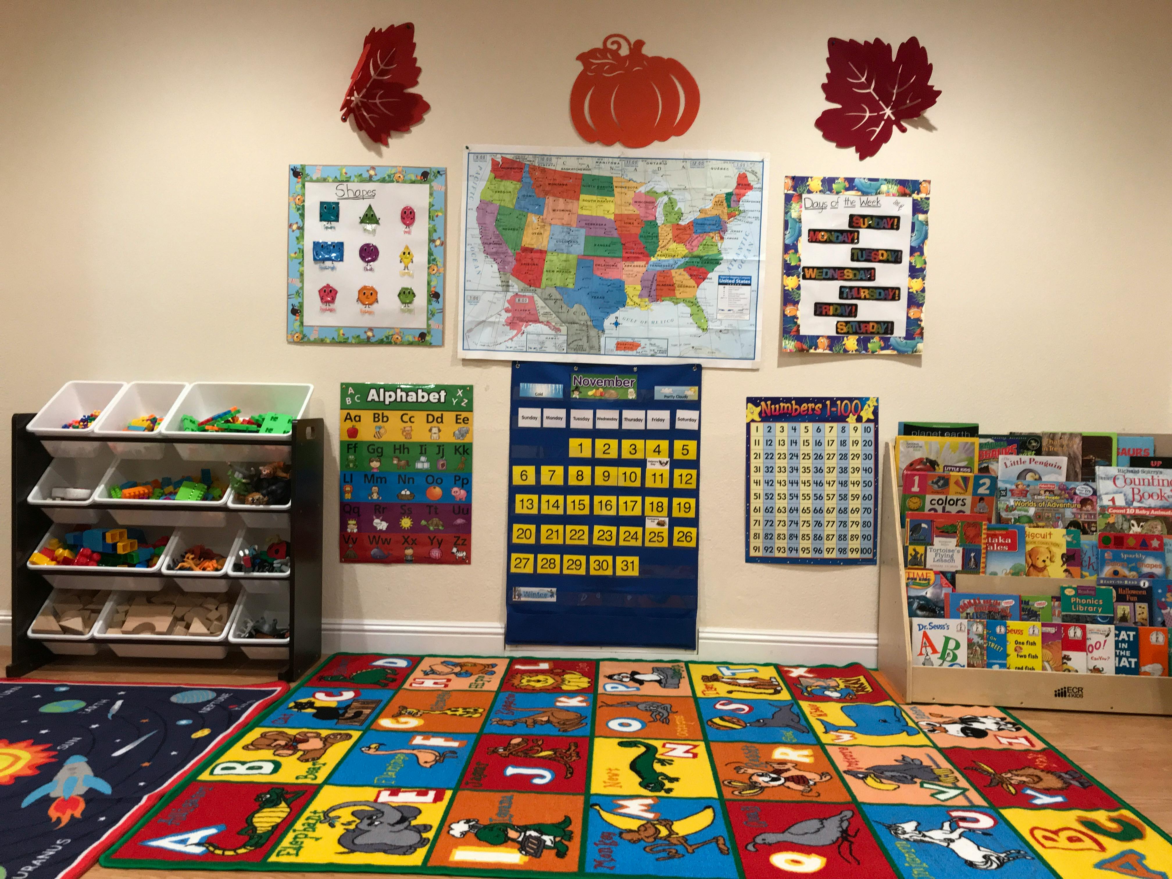 Children's playroom with educational posters, toy storage, and colorful rugs