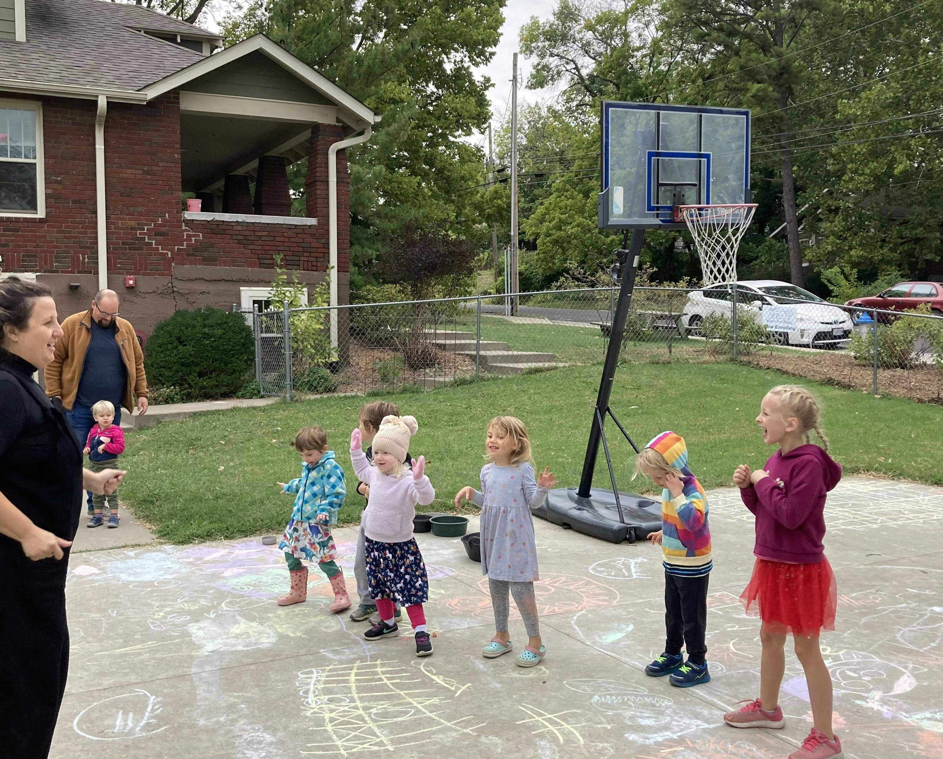 Children playing outdoors with adults nearby