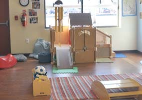 Indoor play structure with a slide and a soccer ball in a box