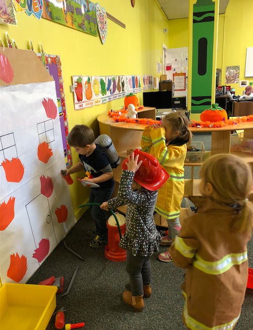Children playing with fire safety props in a classroom