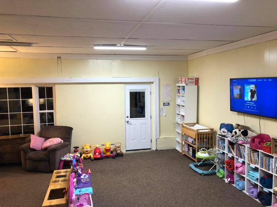 Room with a television, shelves, and children's toys
