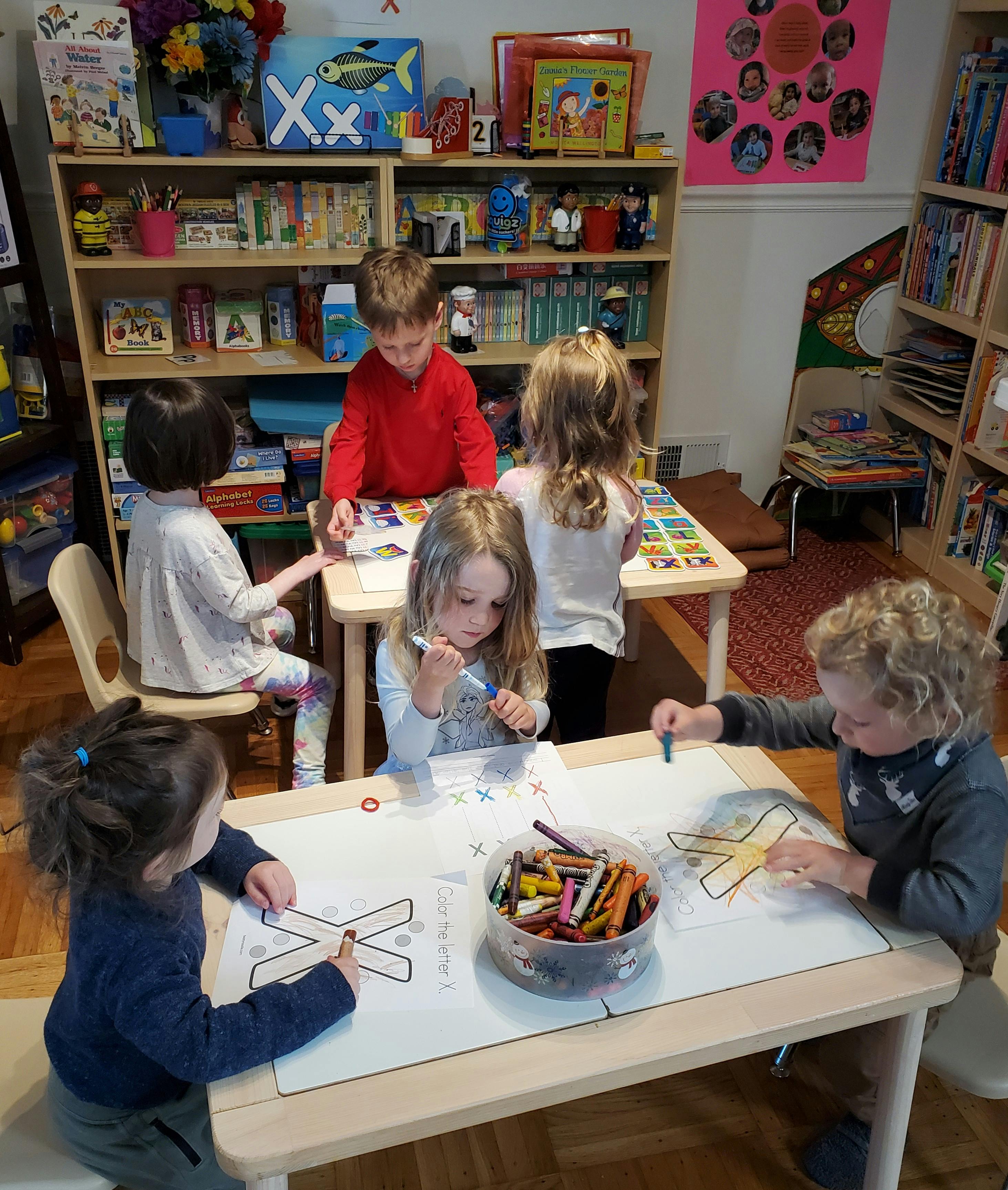 Children coloring at tables in a classroom