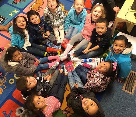 Group of children sitting on a colorful rug