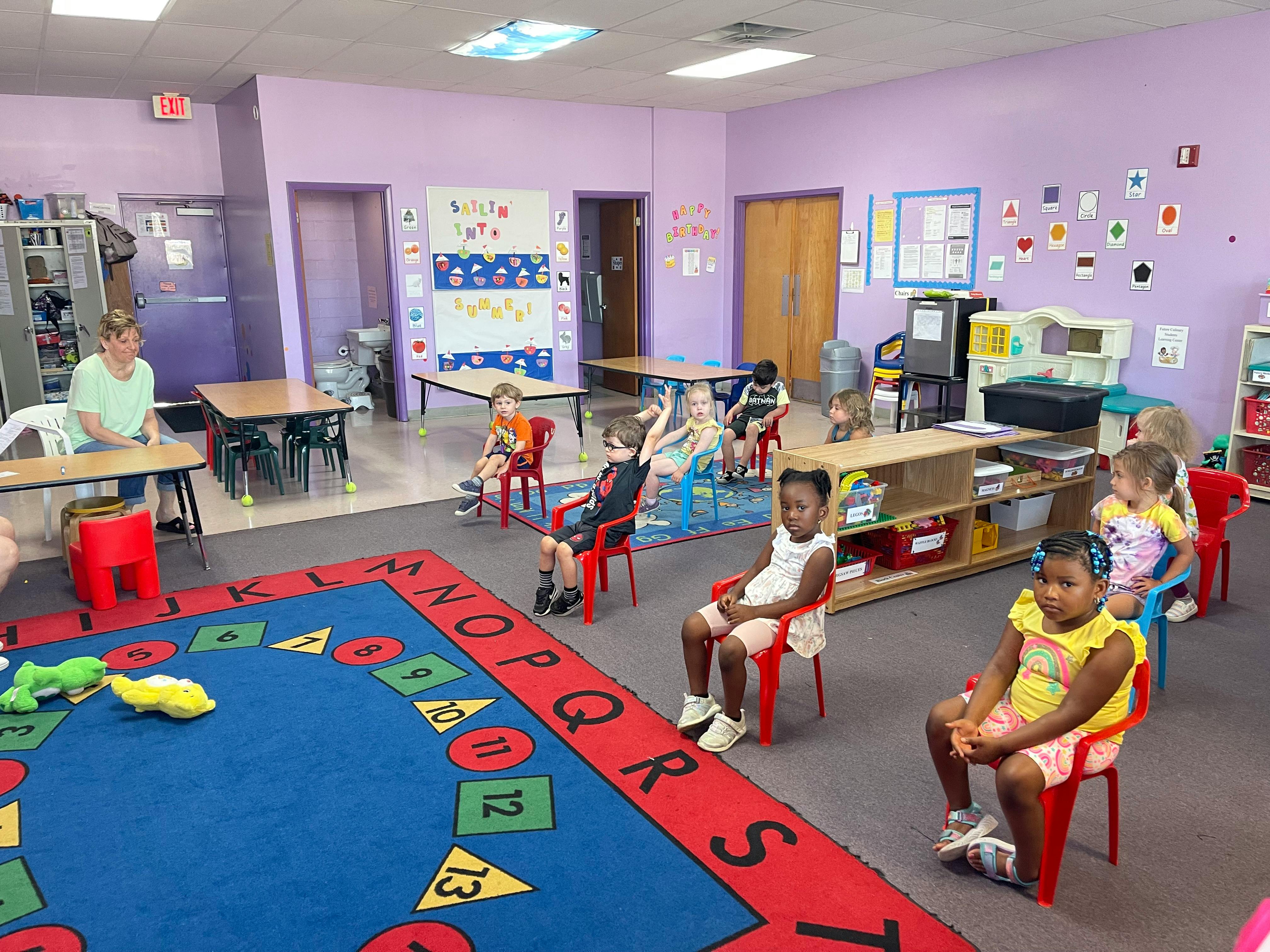 Adult and children sitting in a classroom
