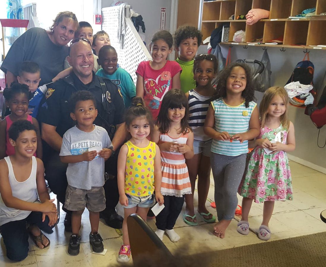 Police officer and adult with a group of children