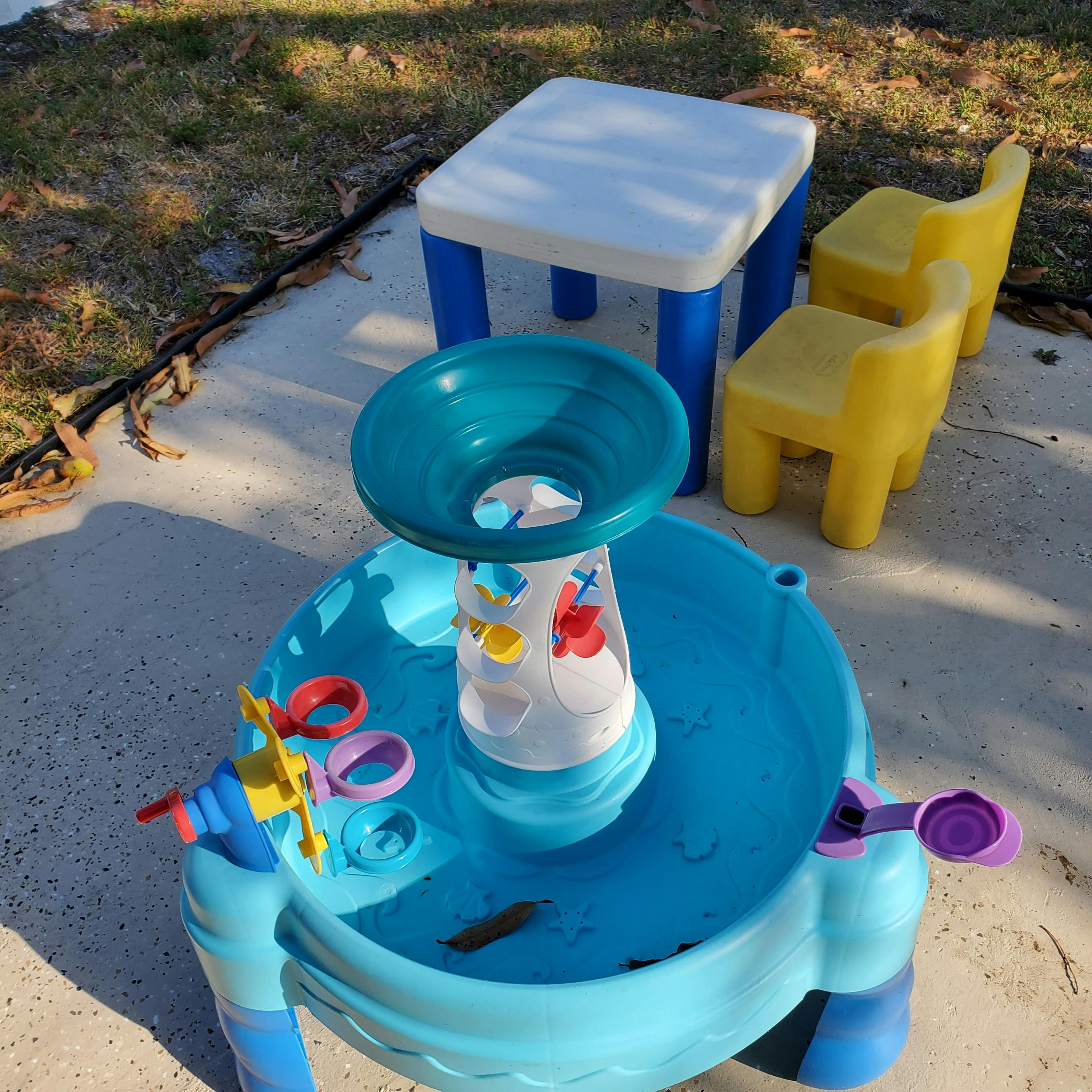 Children's water table with toys, small table, and two chairs