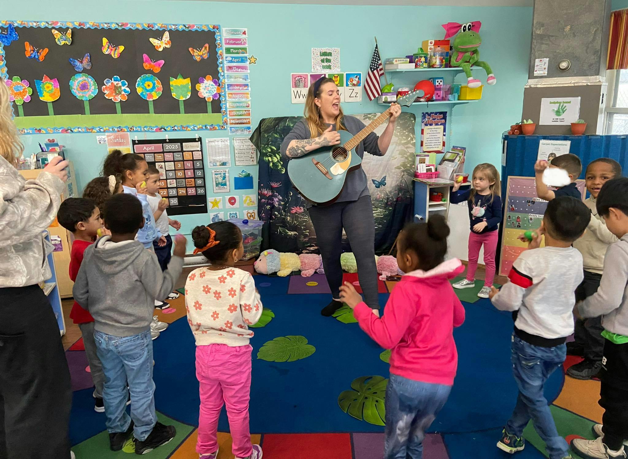 Person playing guitar for children in a classroom