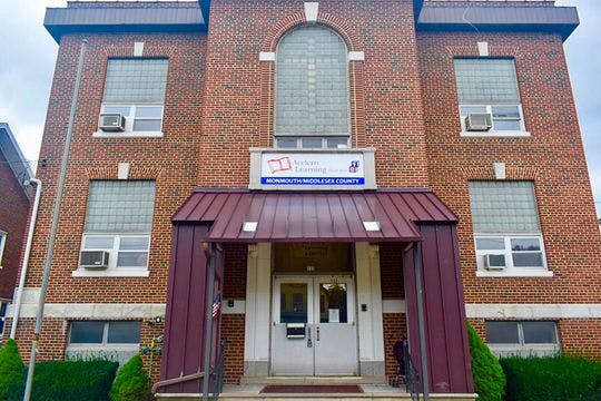 Brick building with a covered entrance and a sign above the door