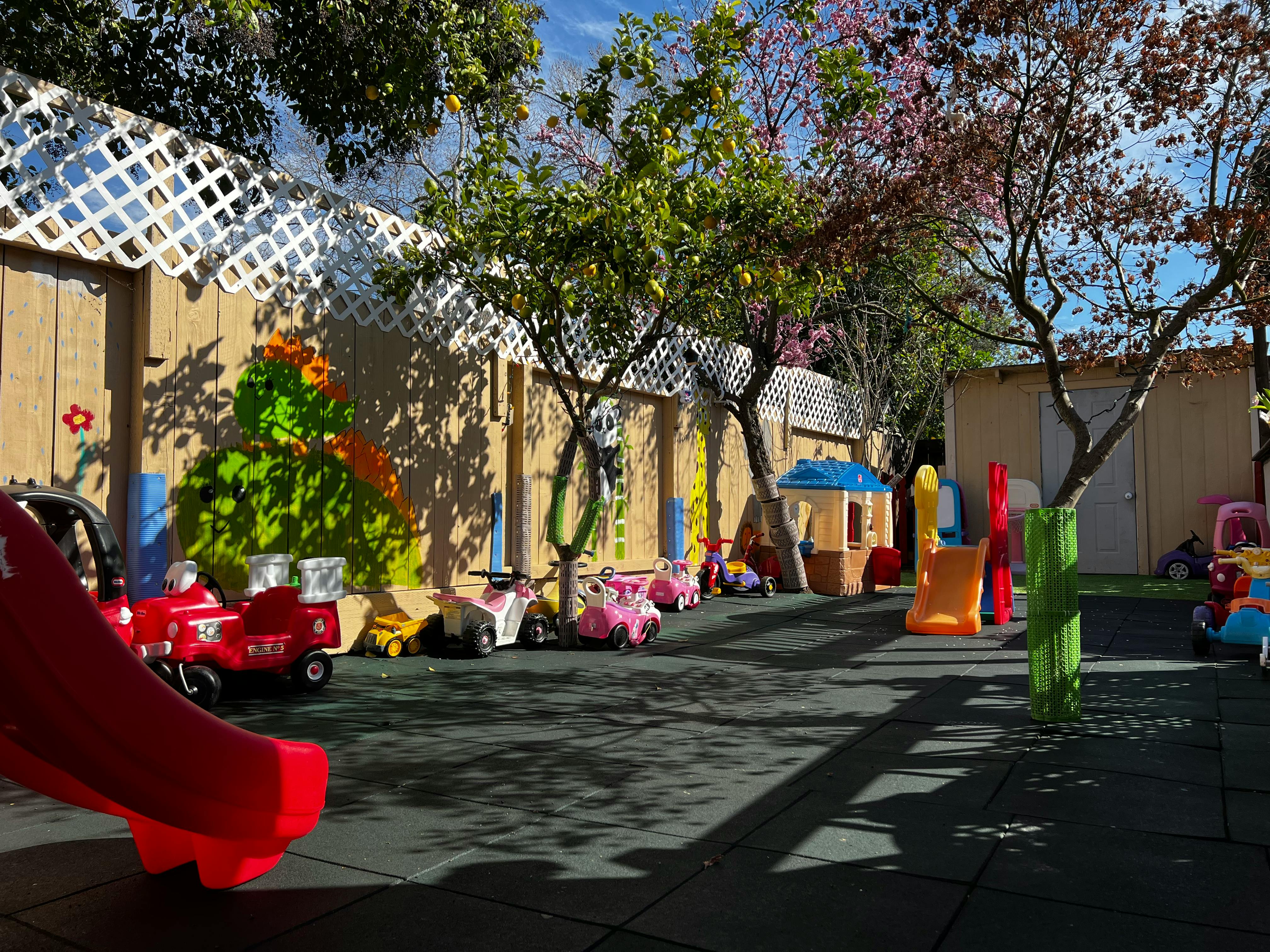Outdoor play area with various ride-on toys and play structures