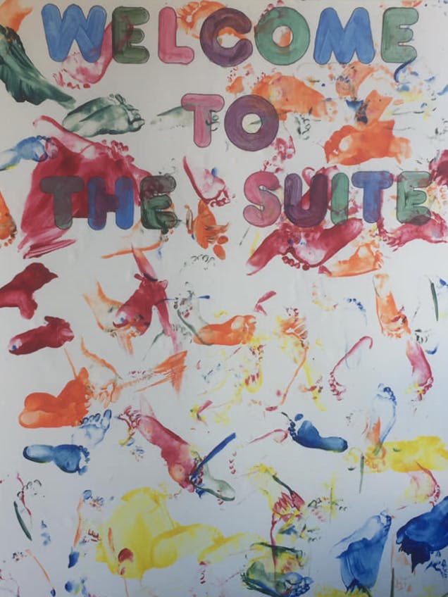 Welcome to the Suite text with colorful hand and foot prints