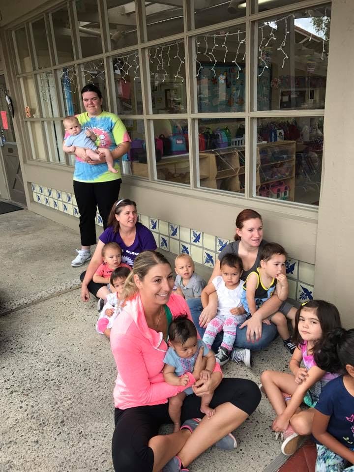 Group of adults and children sitting on the ground