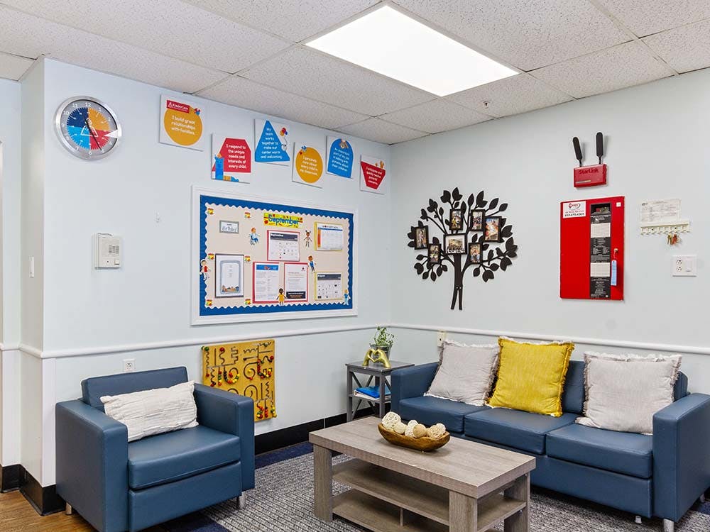 Lobby with a bulletin board, blue couch and armchair, and wall decorations