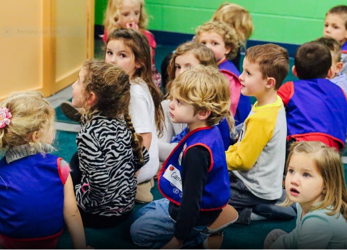 Group of children sitting on the floor looking in the same direction
