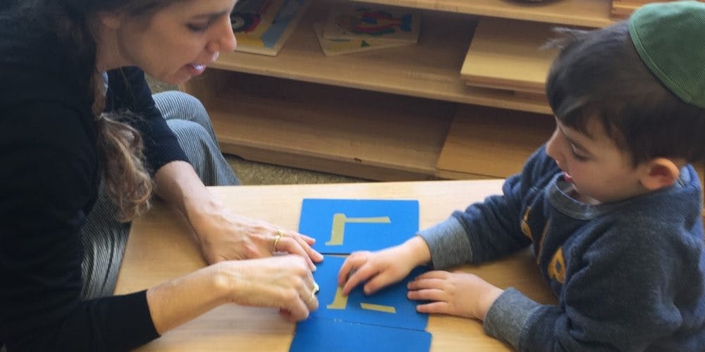 Person and child working with blue and yellow learning materials
