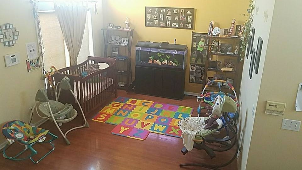 Nursery room with a crib, baby swing, and play mat