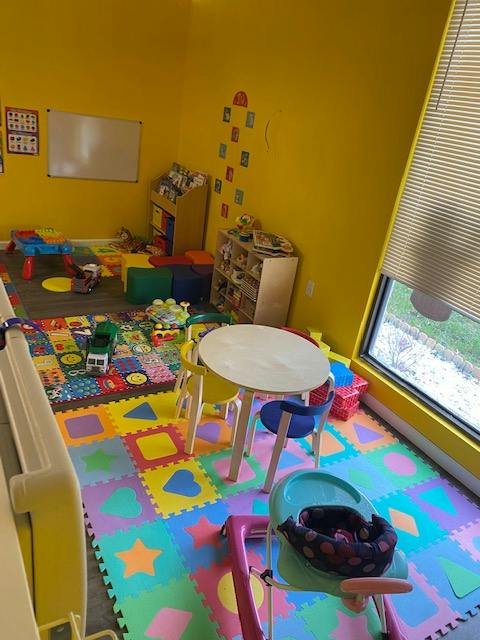 Playroom with colorful floor mats, small table and chairs, and toys