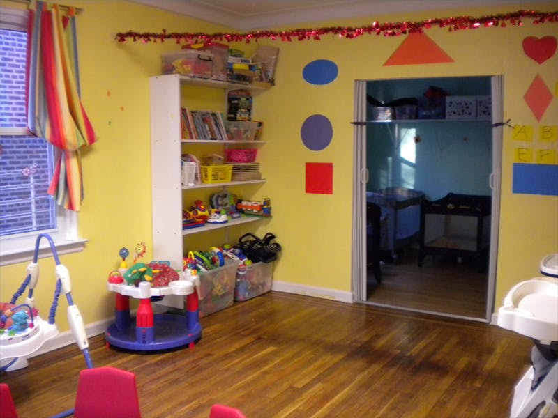 Playroom with shelves of toys, activity table, and shape cutouts on wall