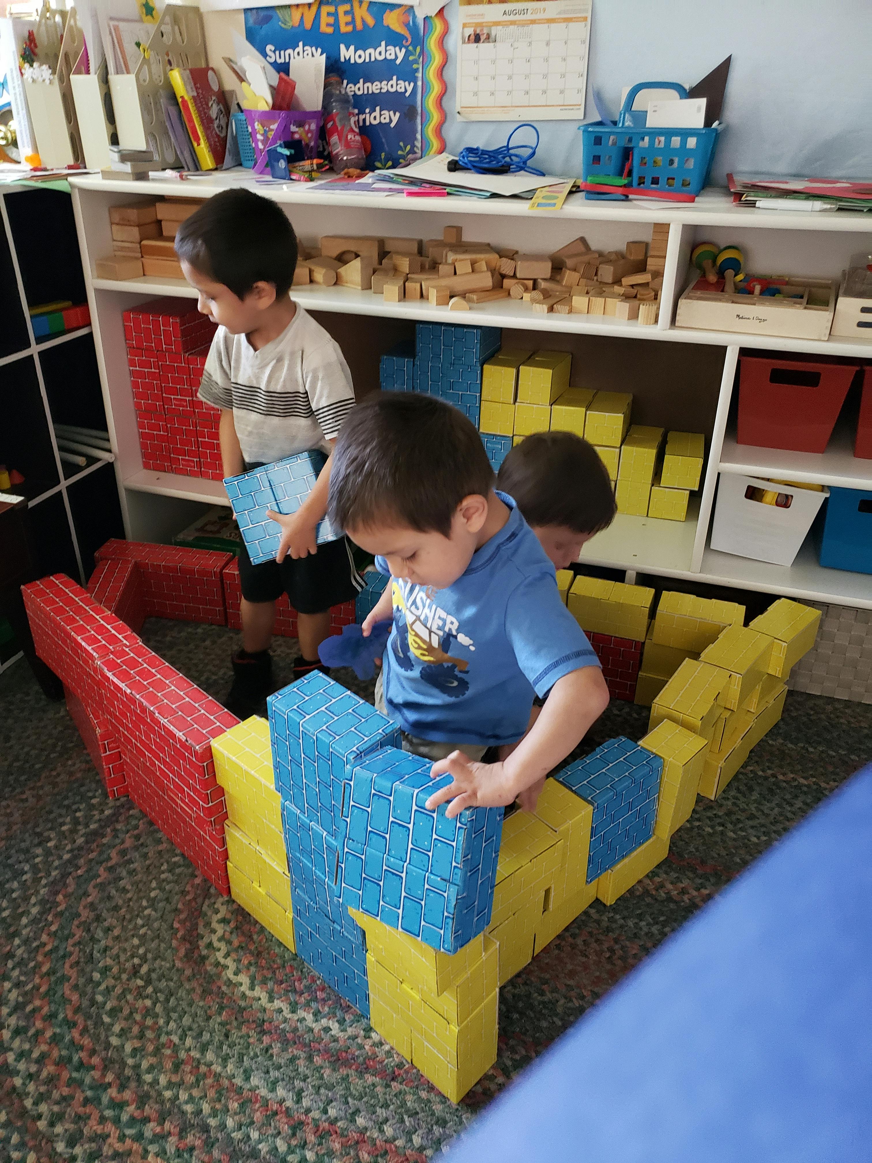Children playing with large building blocks in a classroom