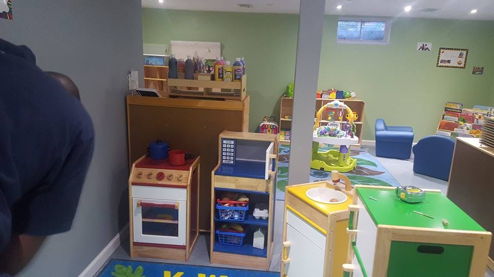 Playroom with toy kitchen, shelves, and small chairs