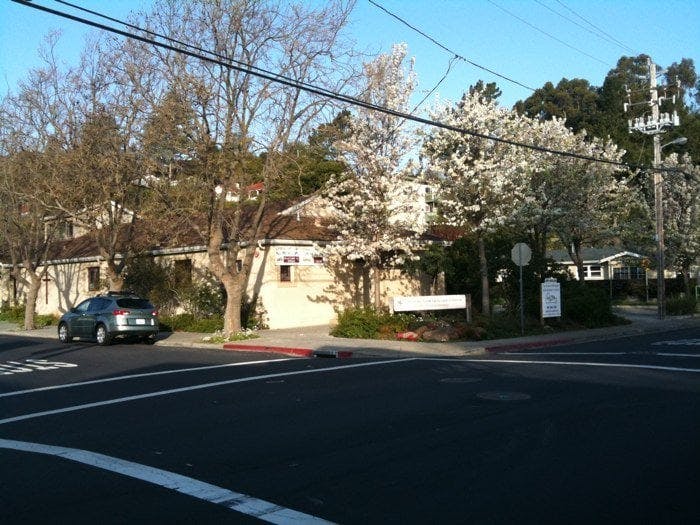 Car parked on a street next to buildings and trees