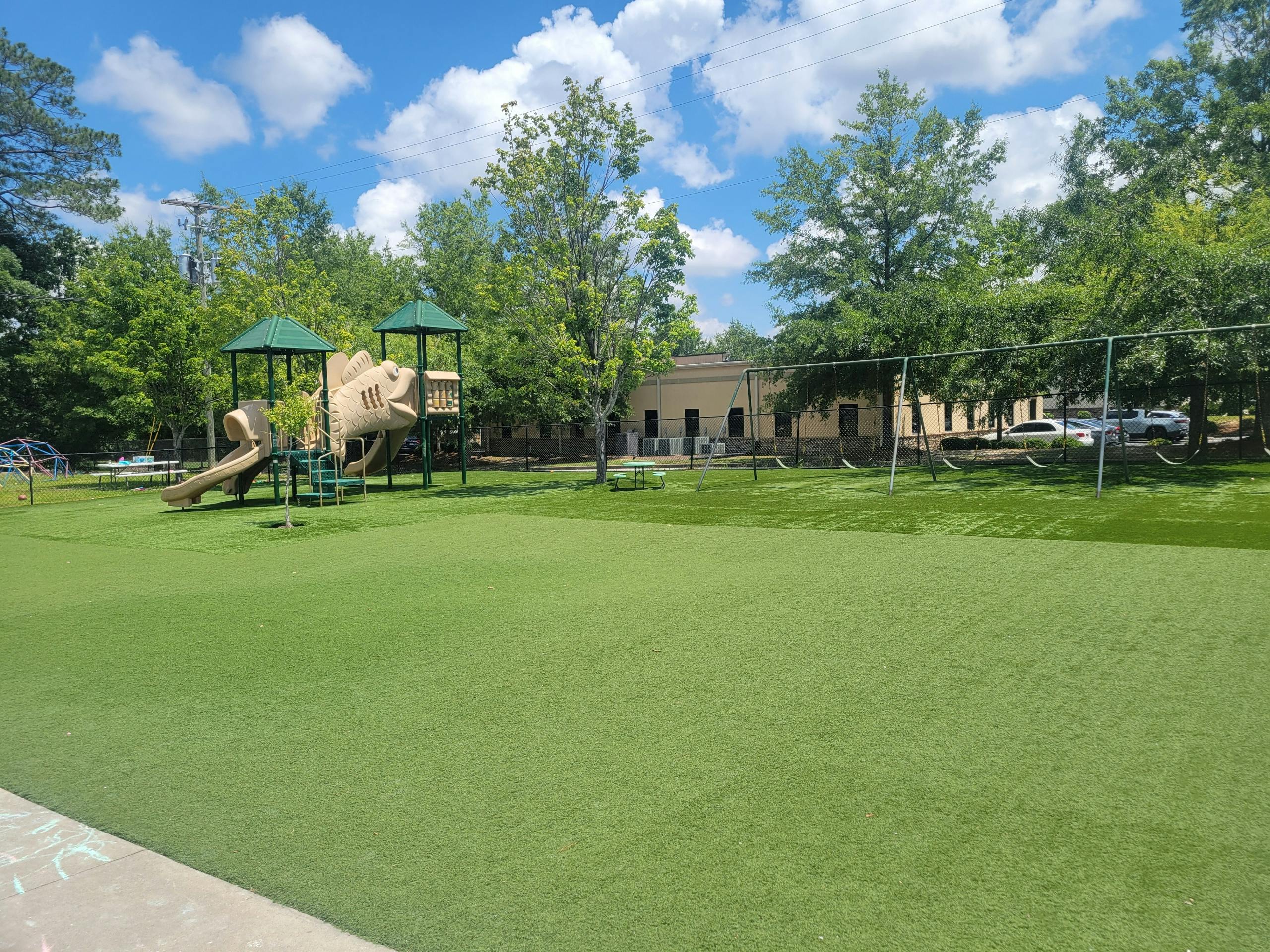 Playground with slides and climbing structures on a green field