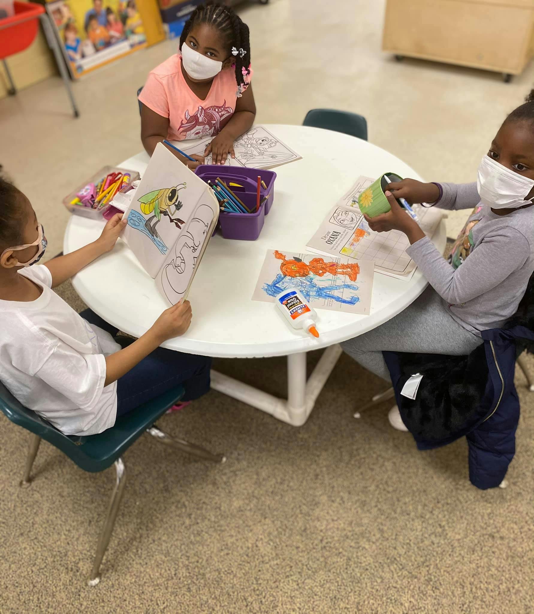 Three children at a table doing crafts