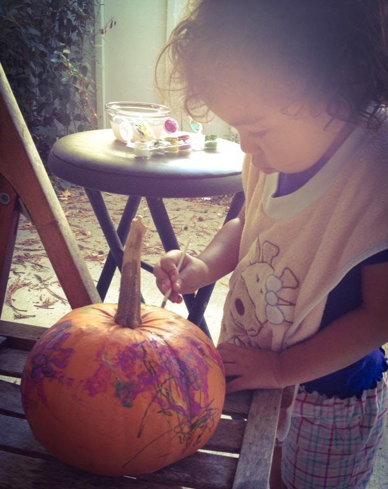 Child painting a pumpkin