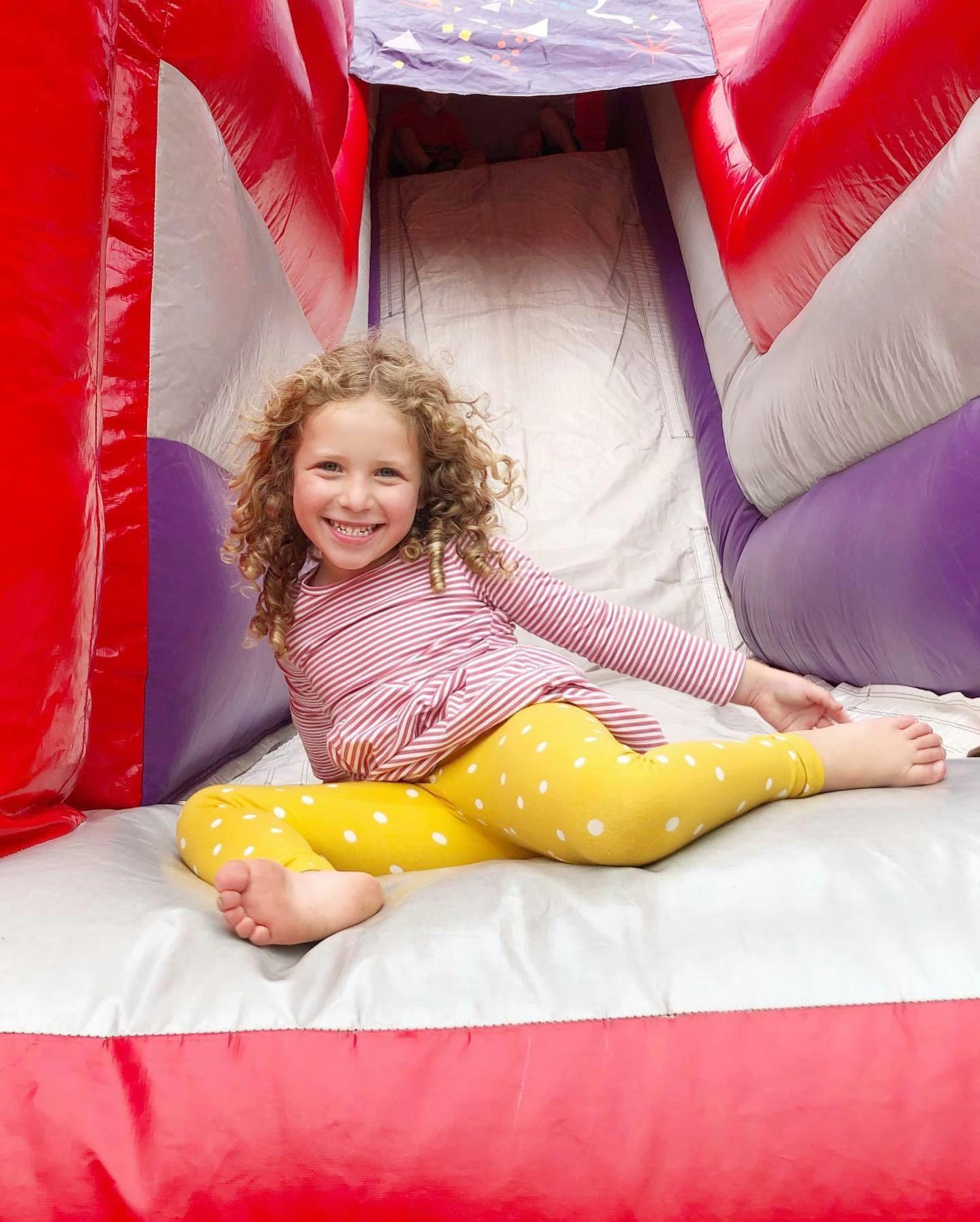 Child sitting on an inflatable slide