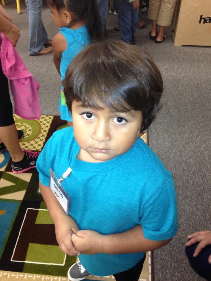 Child in a blue shirt looking up
