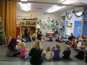 Adults and children sitting in a circle in a classroom