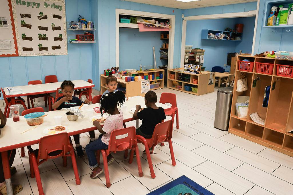 Children eating lunch at a table in a classroom