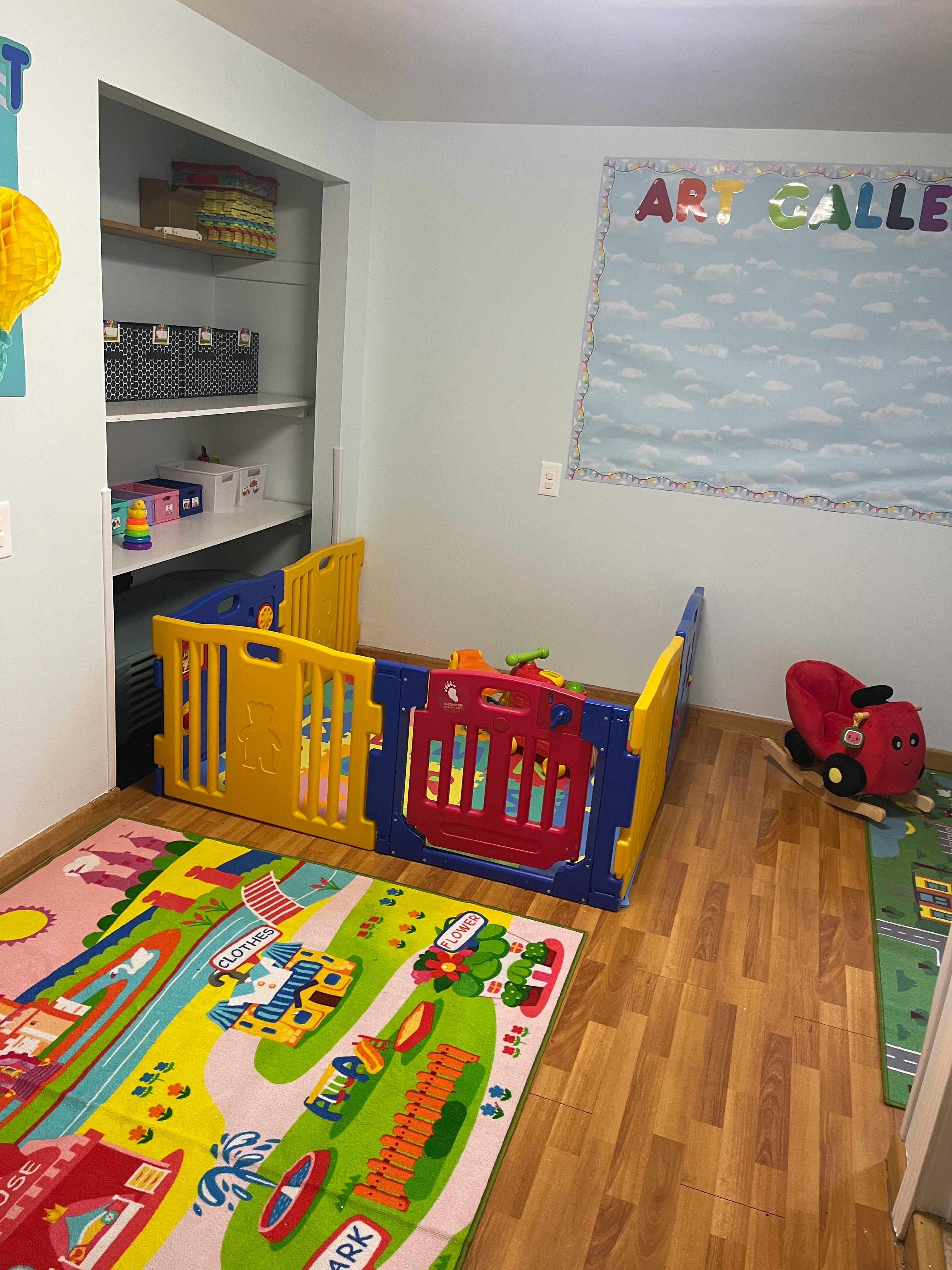 Playpen in a room with a colorful rug and a closet