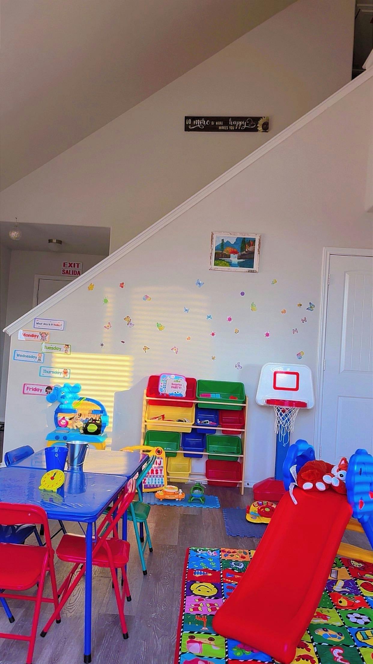 Children's play area with a small table and chairs, toy organizer, and a slide