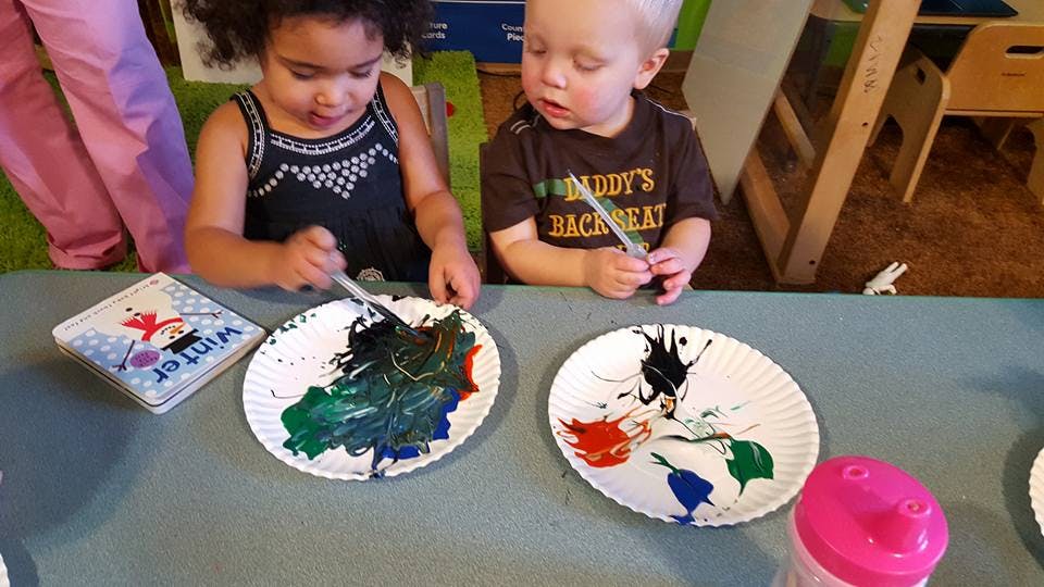 Two children painting on paper plates