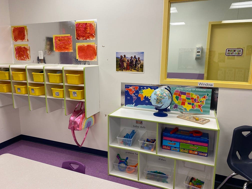 Classroom with cubbies, shelves, and maps