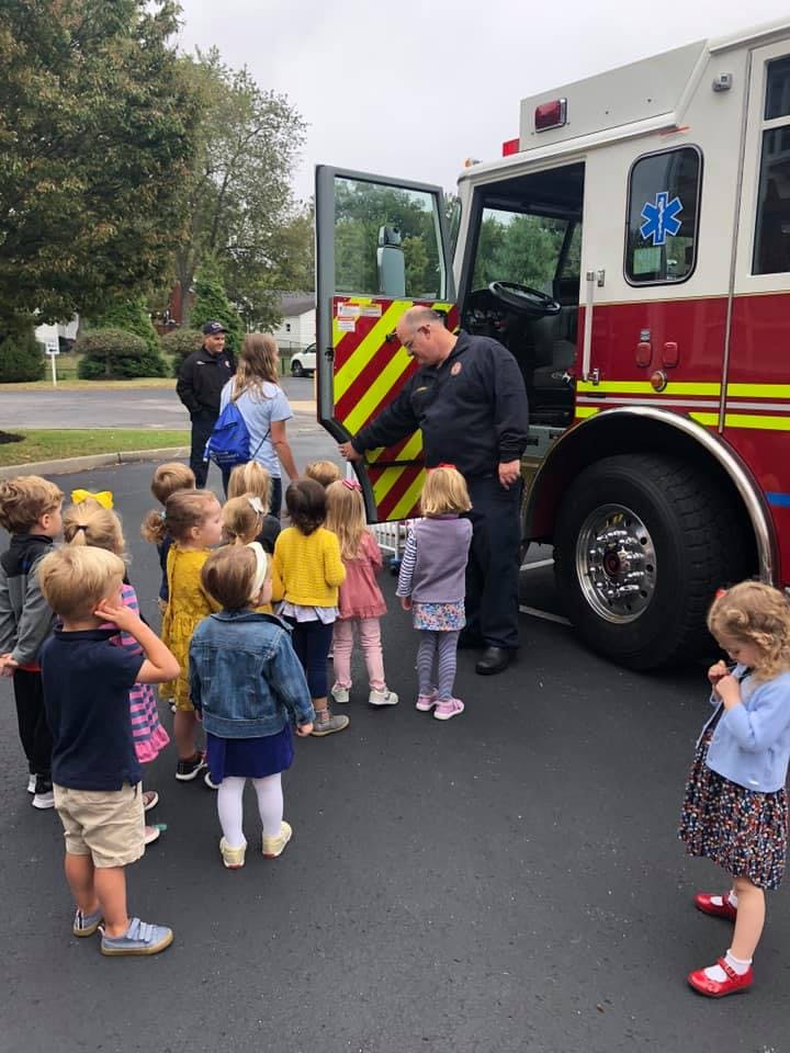 Firefighter showing children the inside of a fire truck