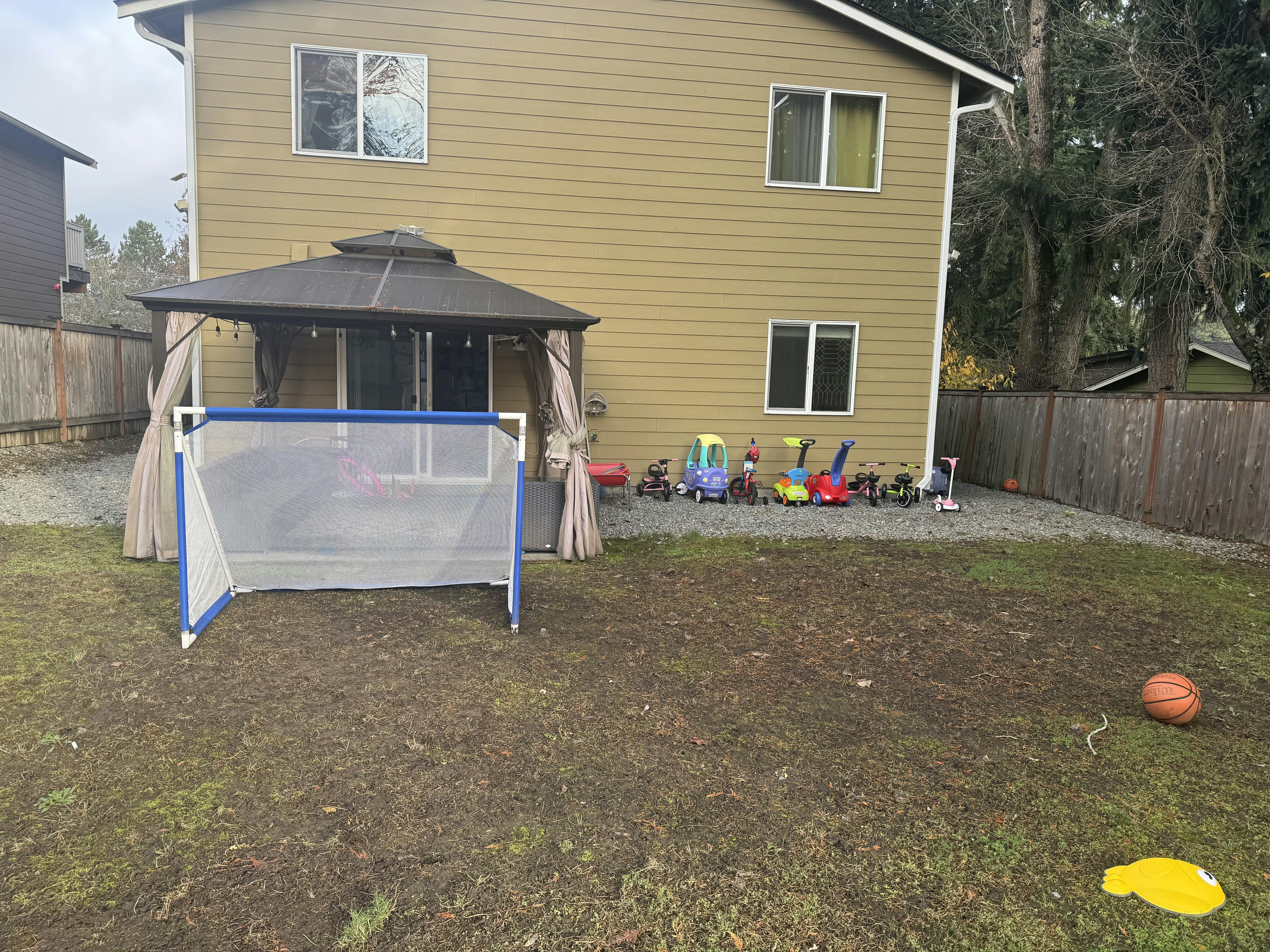Soccer goal in a backyard with a gazebo and house