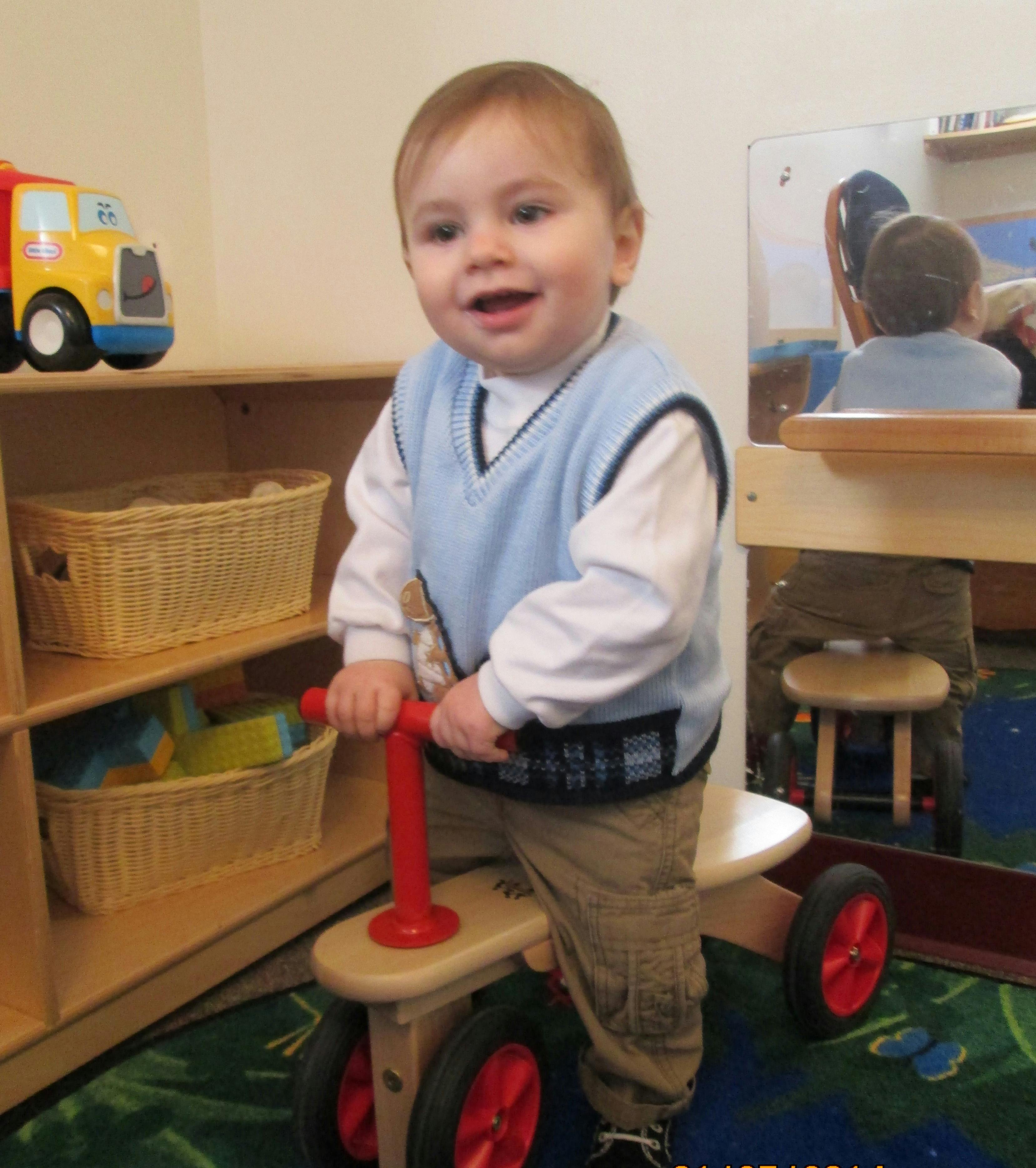 Child on a small ride-on toy in a classroom
