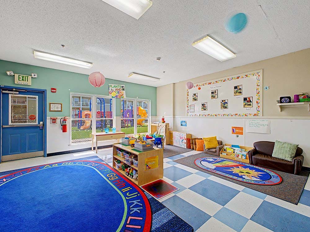 Classroom with child-sized furniture and a view of an outdoor playground