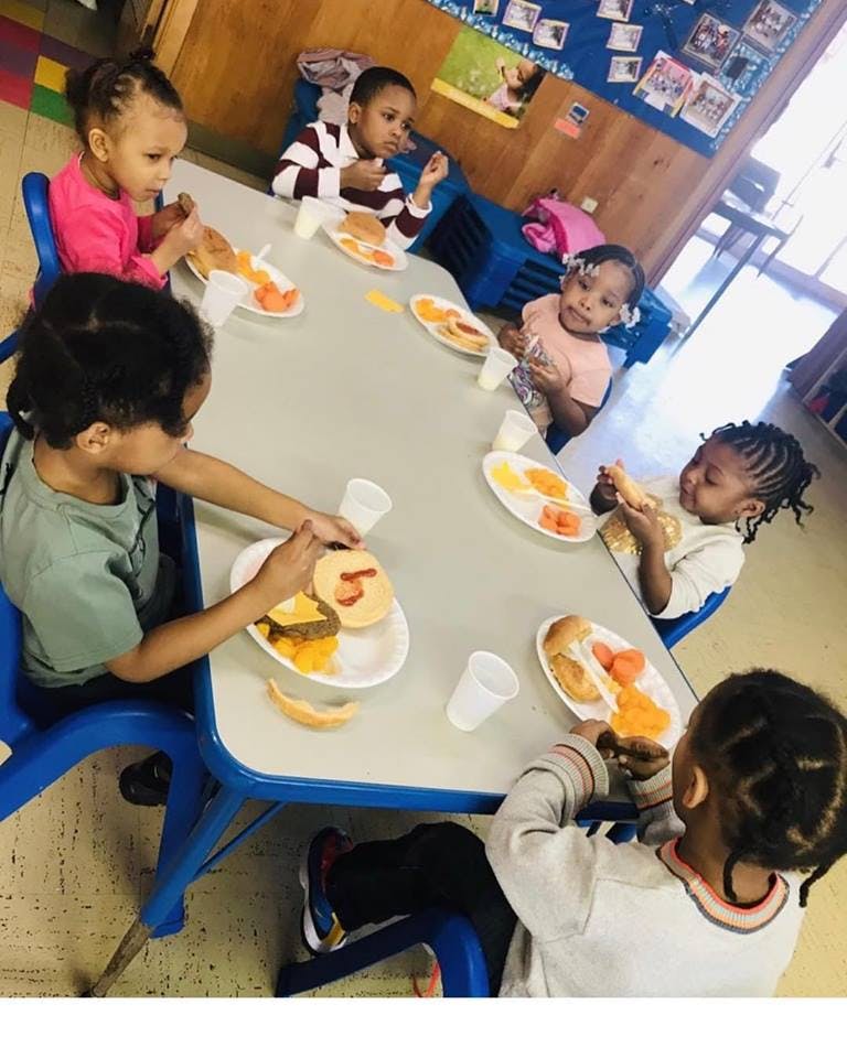 Children eating at a table in a classroom