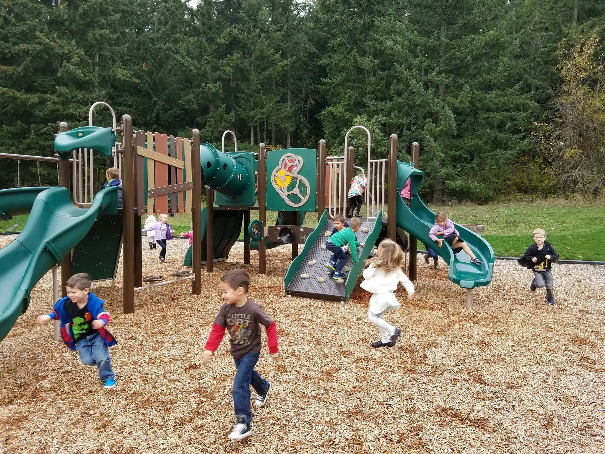 Children playing on a playground with slides and climbing structures