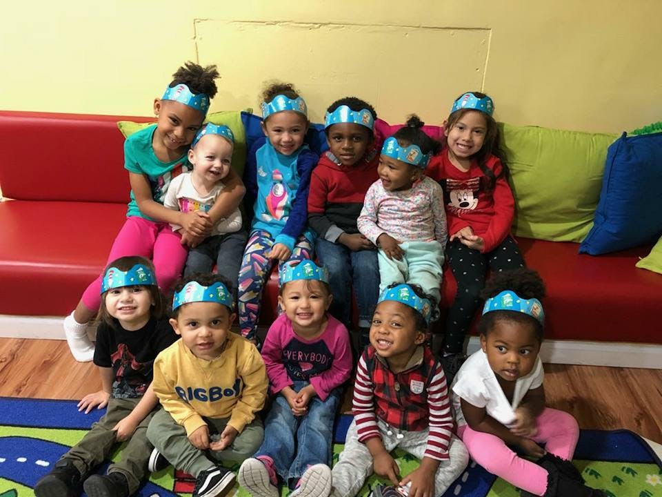 Group of children wearing headbands, some sitting on a couch, some on the floor