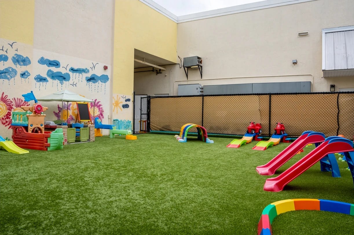 Outdoor play area with artificial turf and colorful play equipment