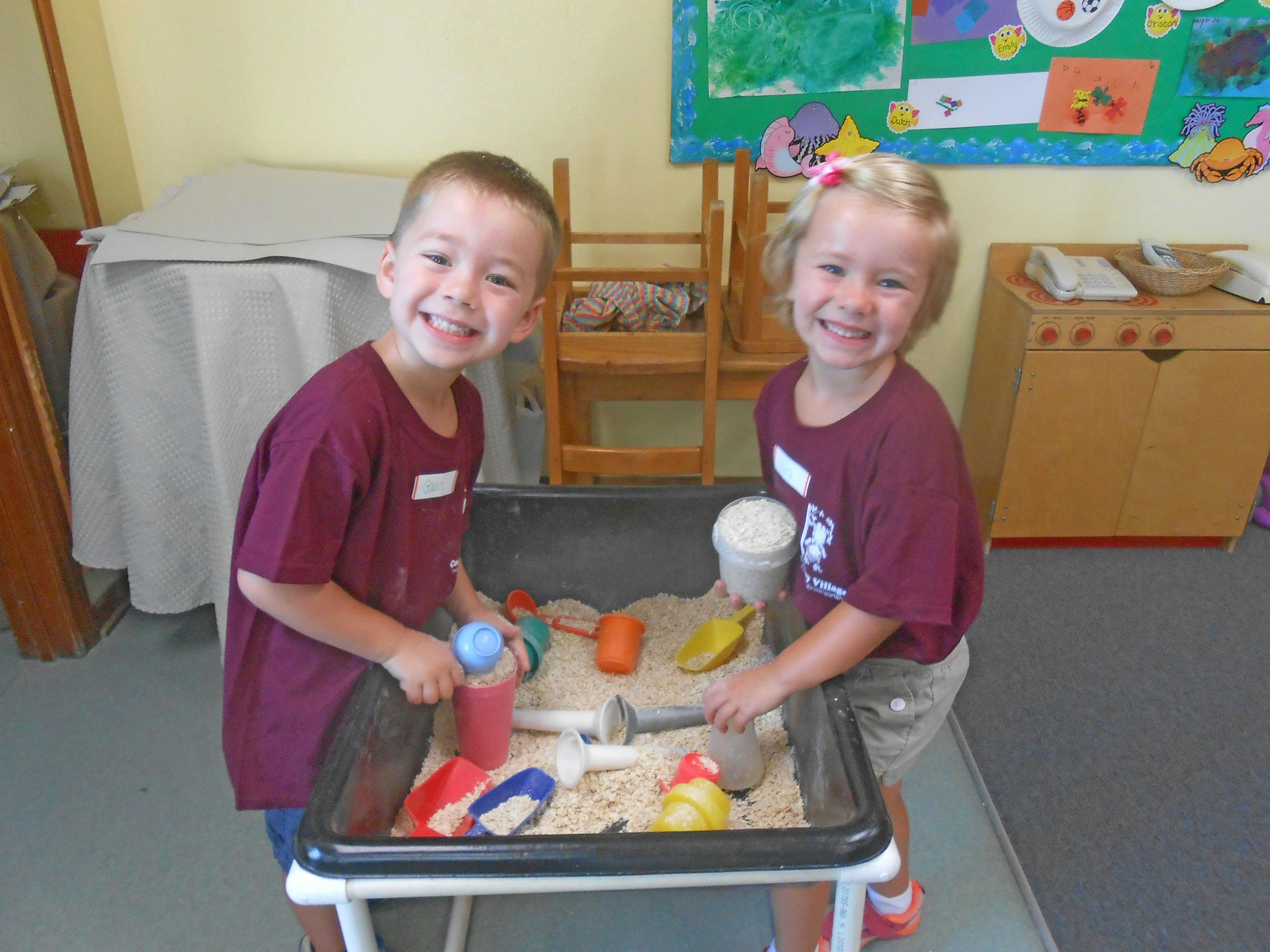 Two children playing in a sand table