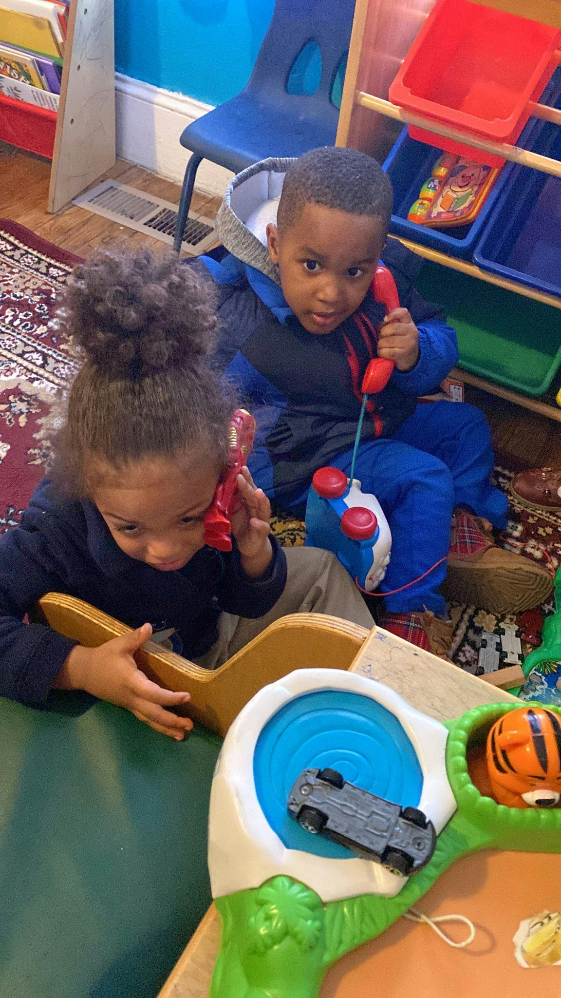 Two children playing with toy phones